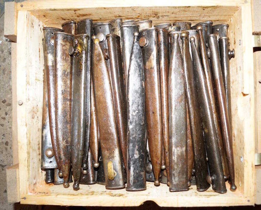 Loose M1935 bayonet scabbards in better condition than those listed above and covered with grease.